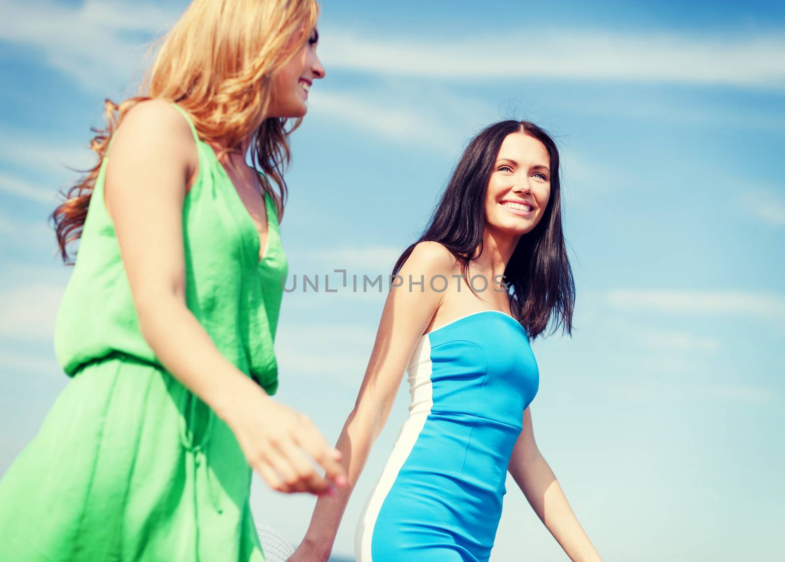 girls walking on the beach by dolgachov