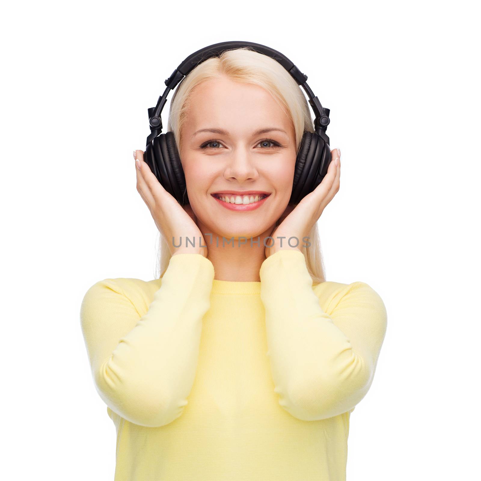 music and technology concept - smiling young woman listening to music with headphones