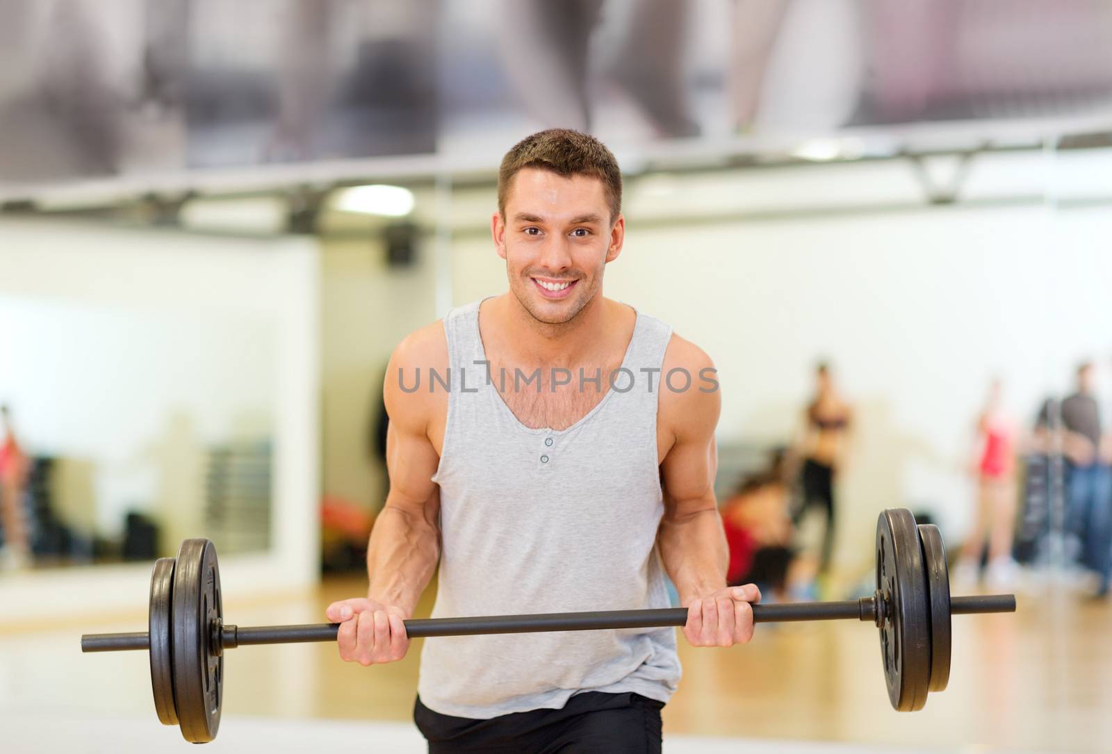 smiling man with barbell in gym by dolgachov