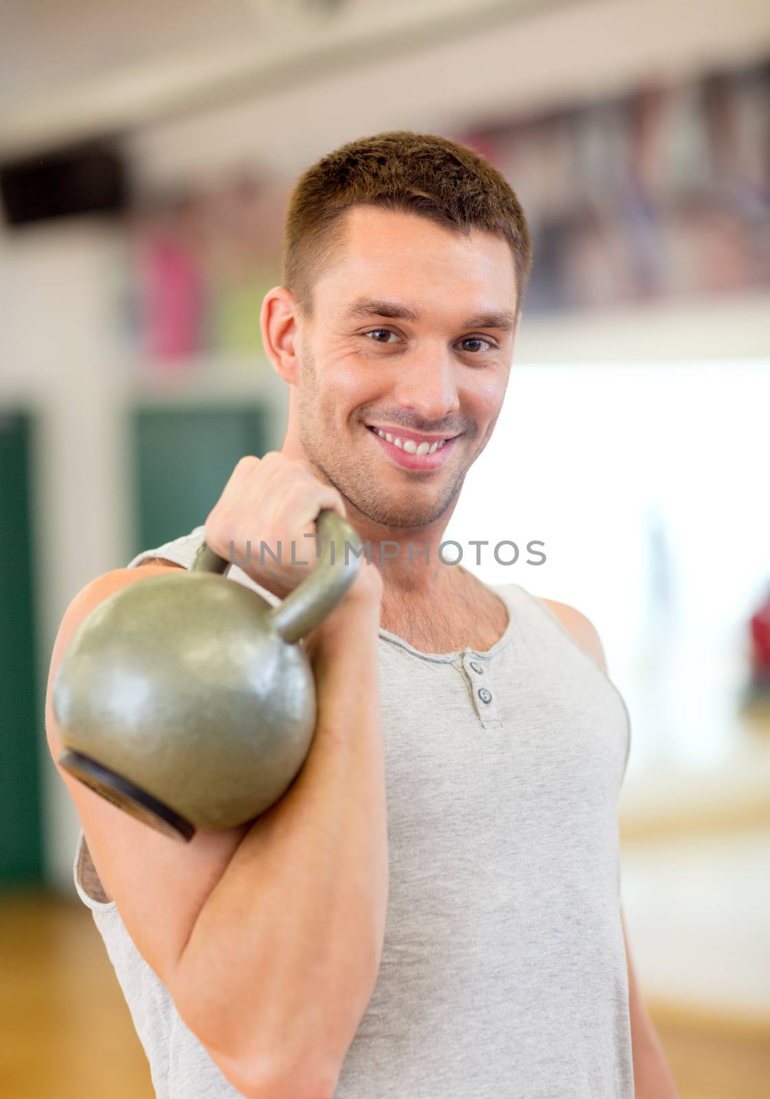 fitness, sport, training, gym and lifestyle concept - smiling man with kettlebell in gym