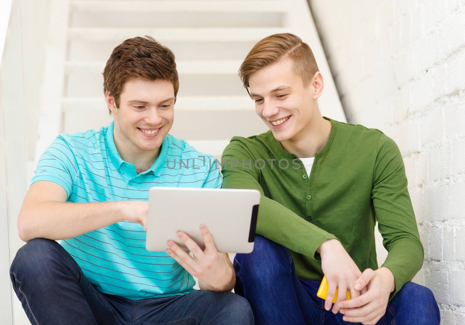 smiling male students with tablet pc computer by dolgachov