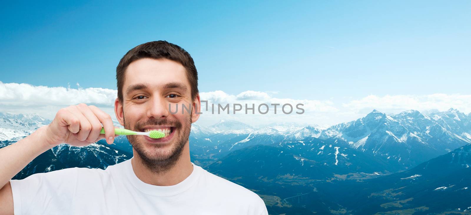 smiling young man with toothbrush by dolgachov