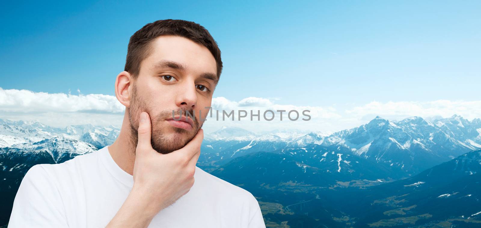 health and beauty concept - beautiful calm man touching his face