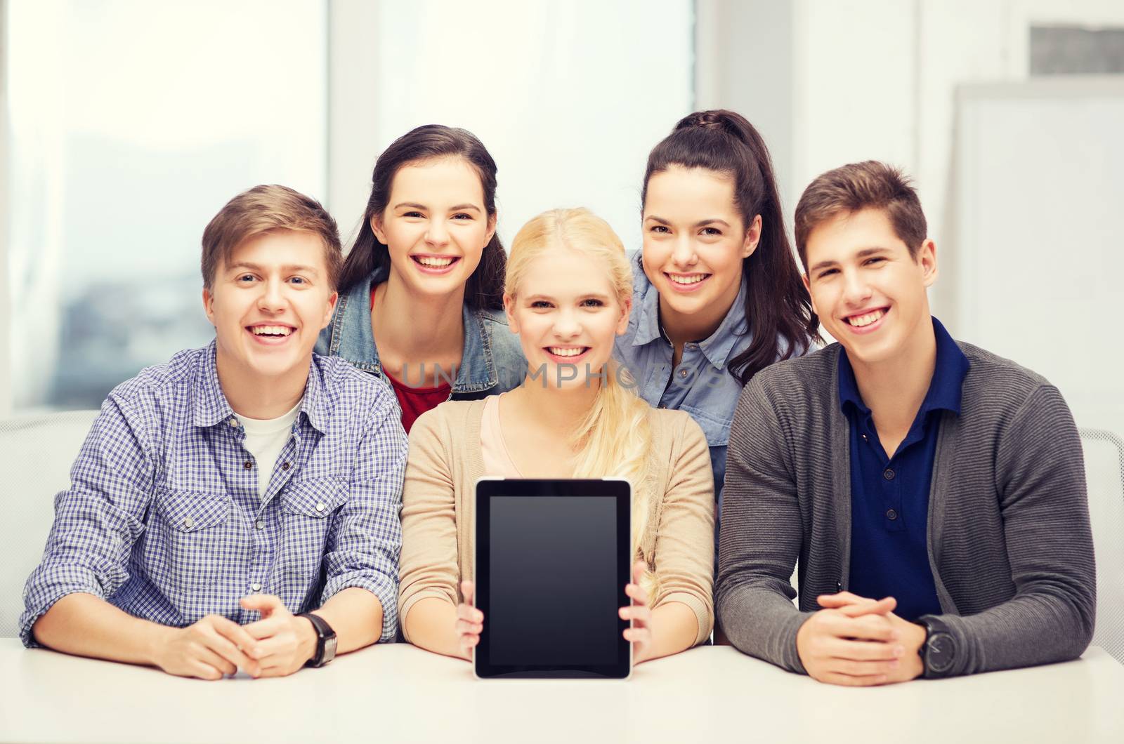 smiling students with blank tablet pc screen by dolgachov