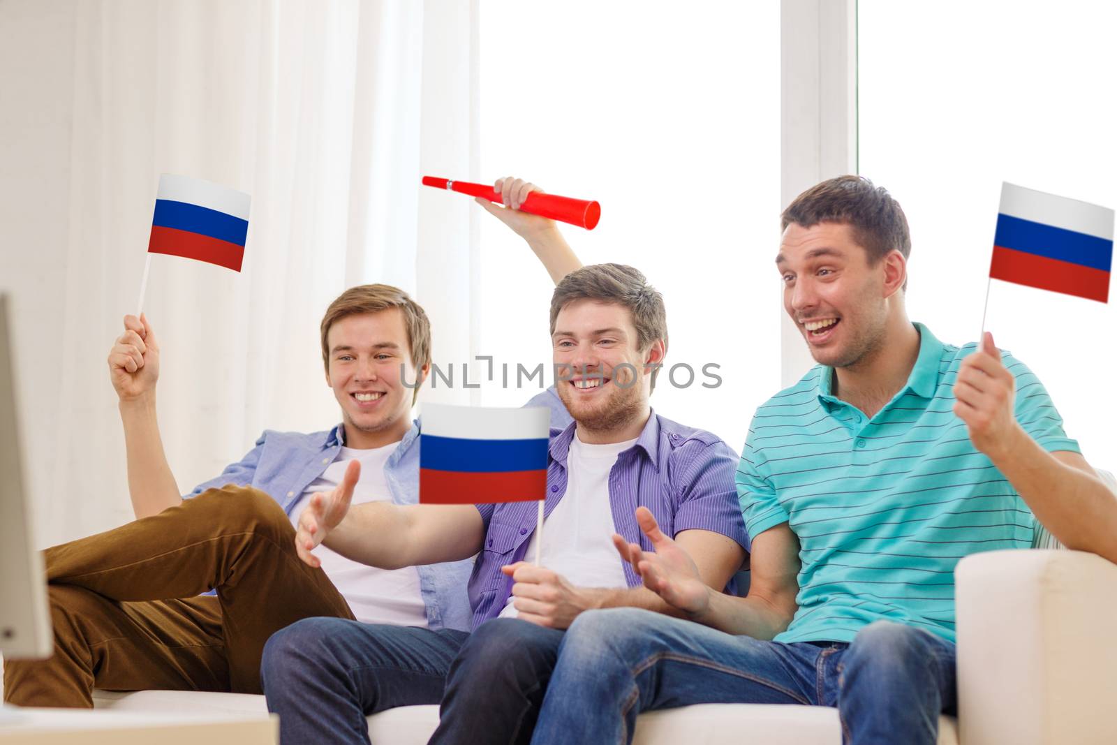 happy male friends with flags and vuvuzela by dolgachov