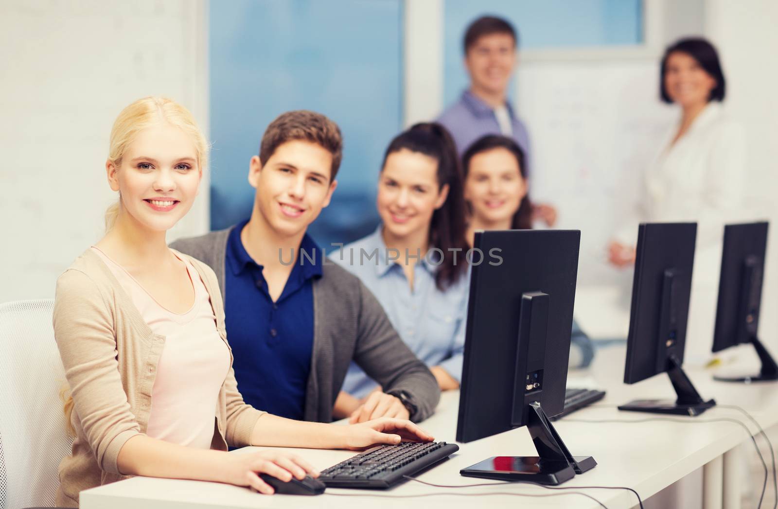 education, technology and internet concept - students looking at computer monitor at school