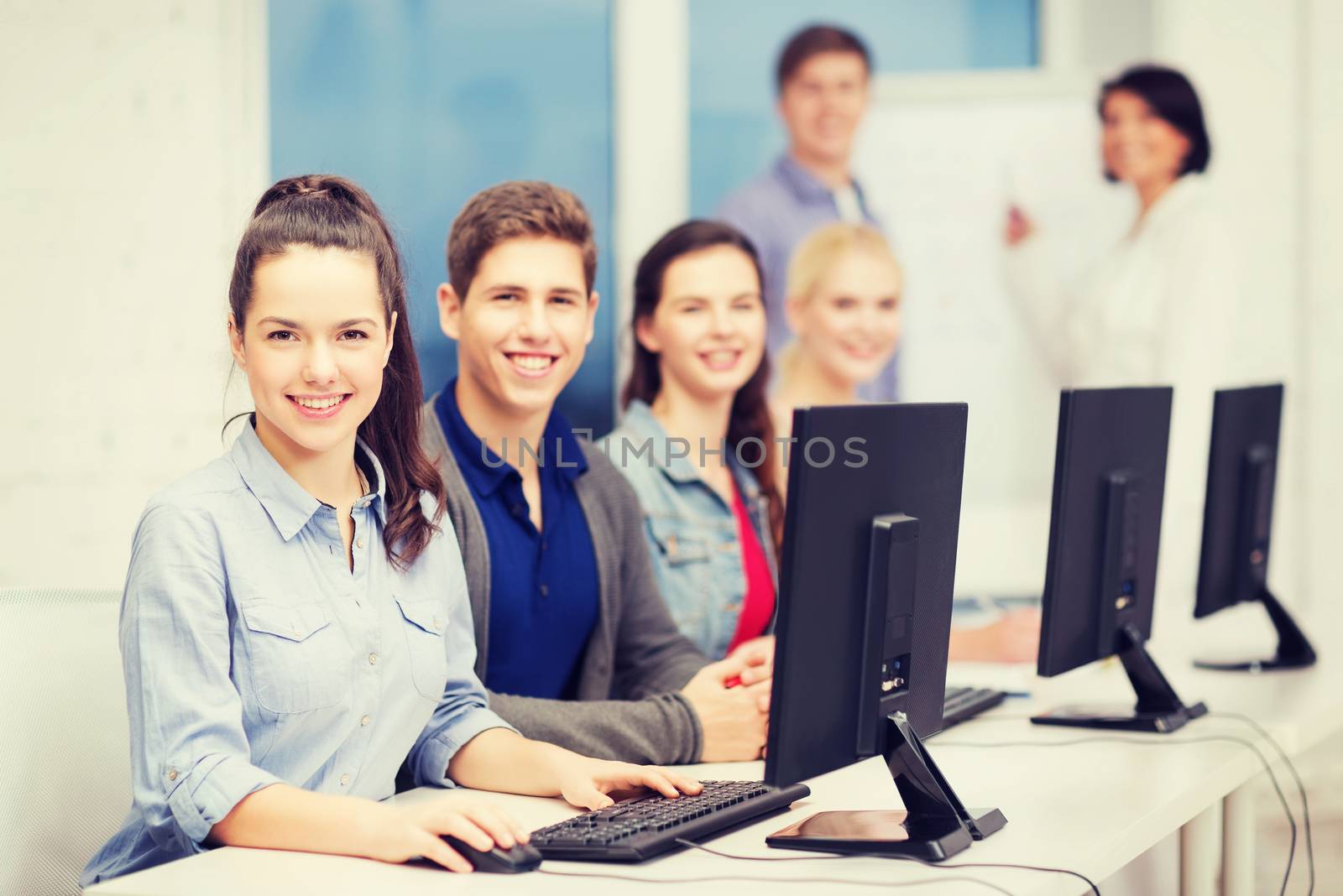 education, technology and internet concept - students looking at computer monitor at school