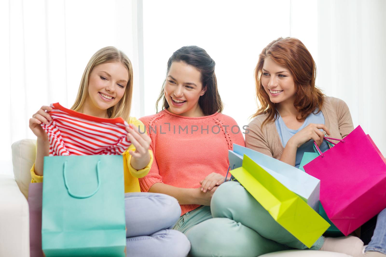 shopping and lifestyle concept - three smiling teenage girls with many shopping bags at home