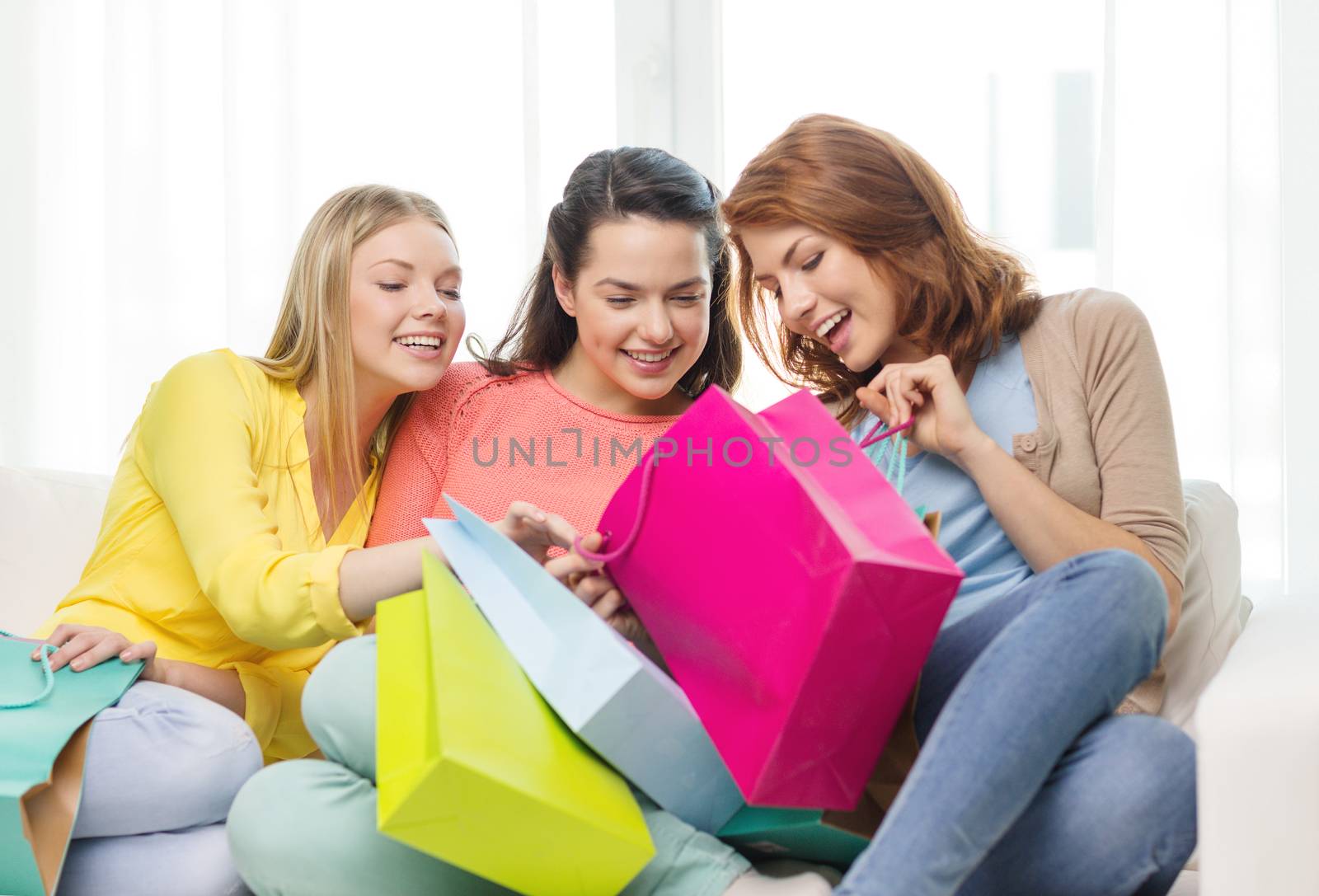 smiling teenage girls with many shopping bags by dolgachov