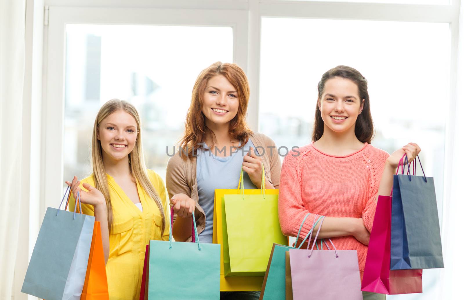 smiling teenage girls with many shopping bags by dolgachov