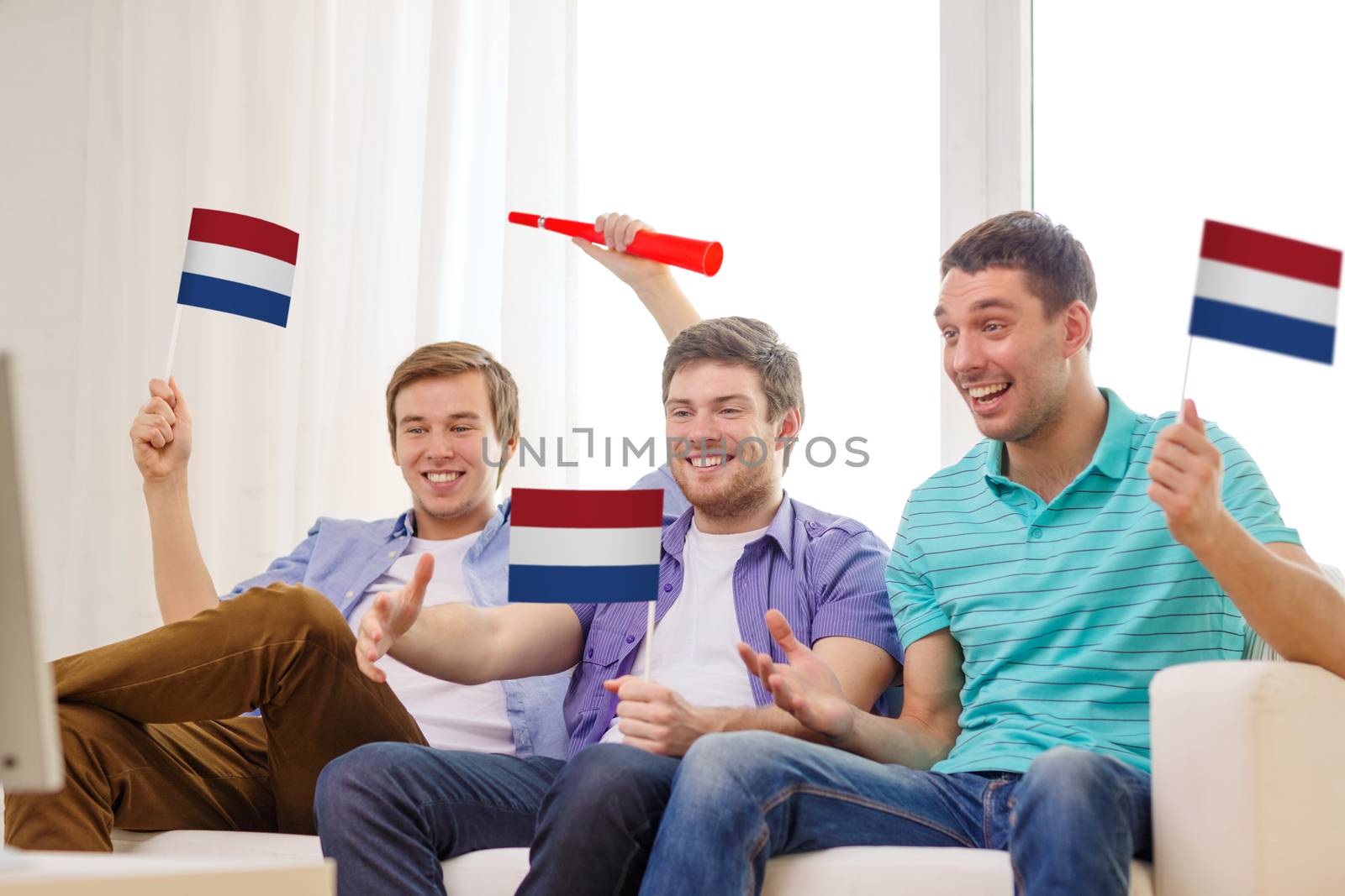 happy male friends with flags and vuvuzela by dolgachov