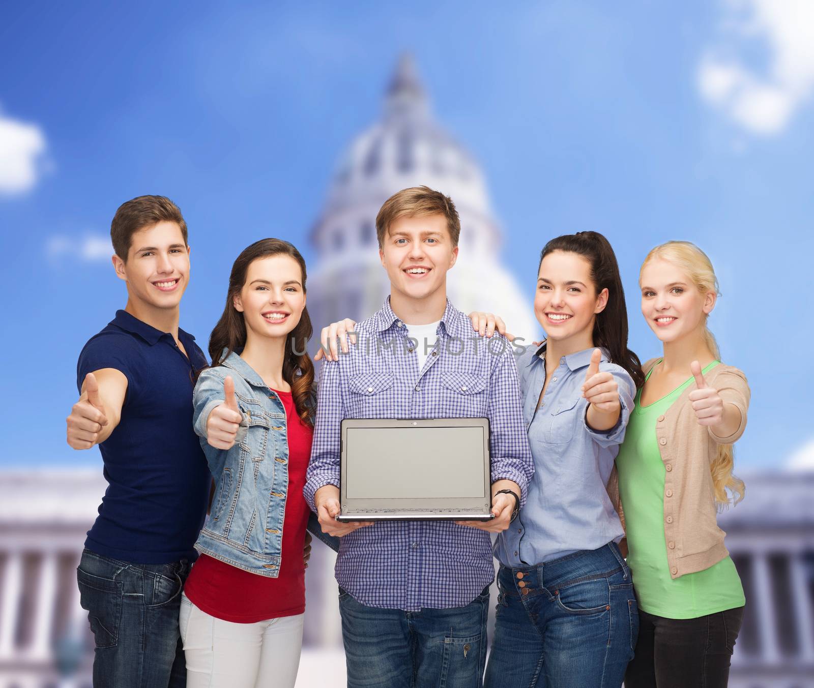 smiling students with laptop computer by dolgachov