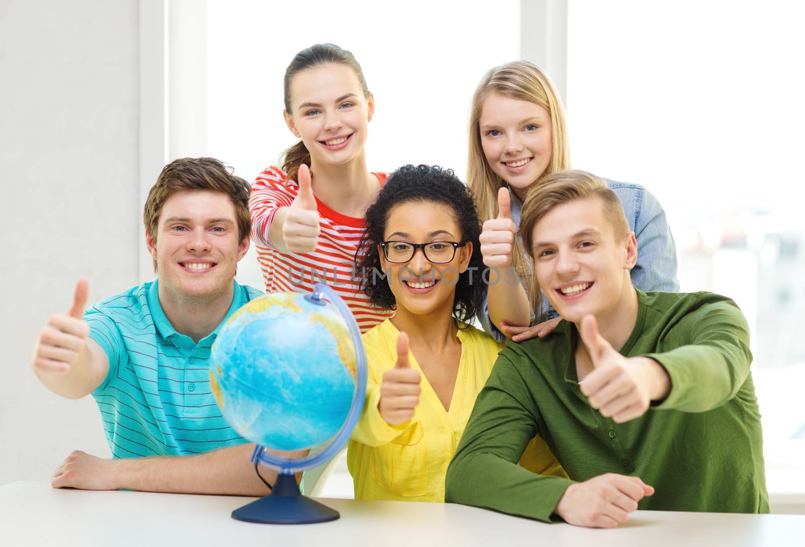 five smiling student with earth globe at school by dolgachov