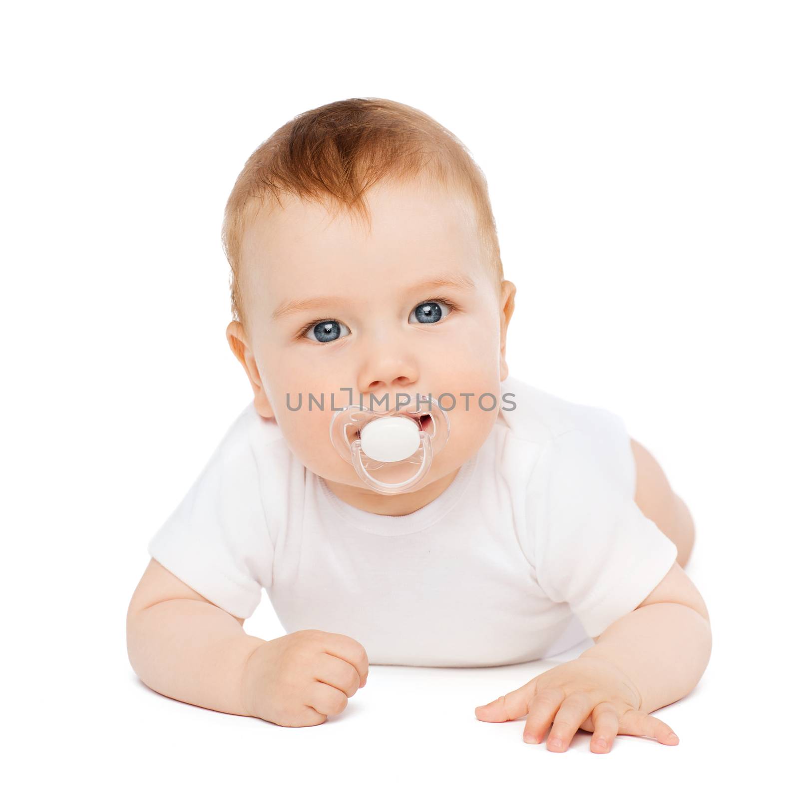 child and toddler concept - smiling baby lying on floor with dummy in mouth