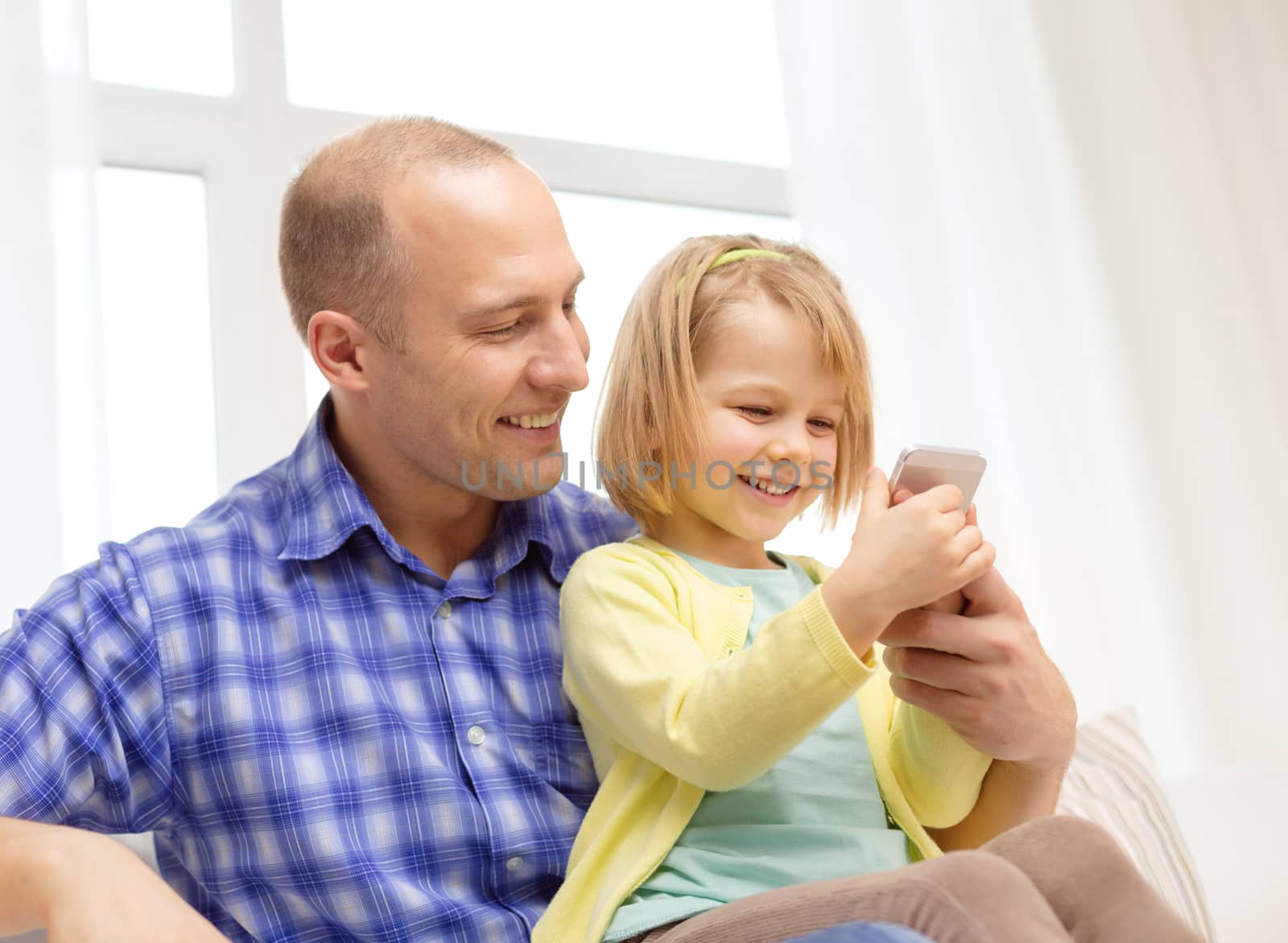 happy father and daughter with smartphone by dolgachov