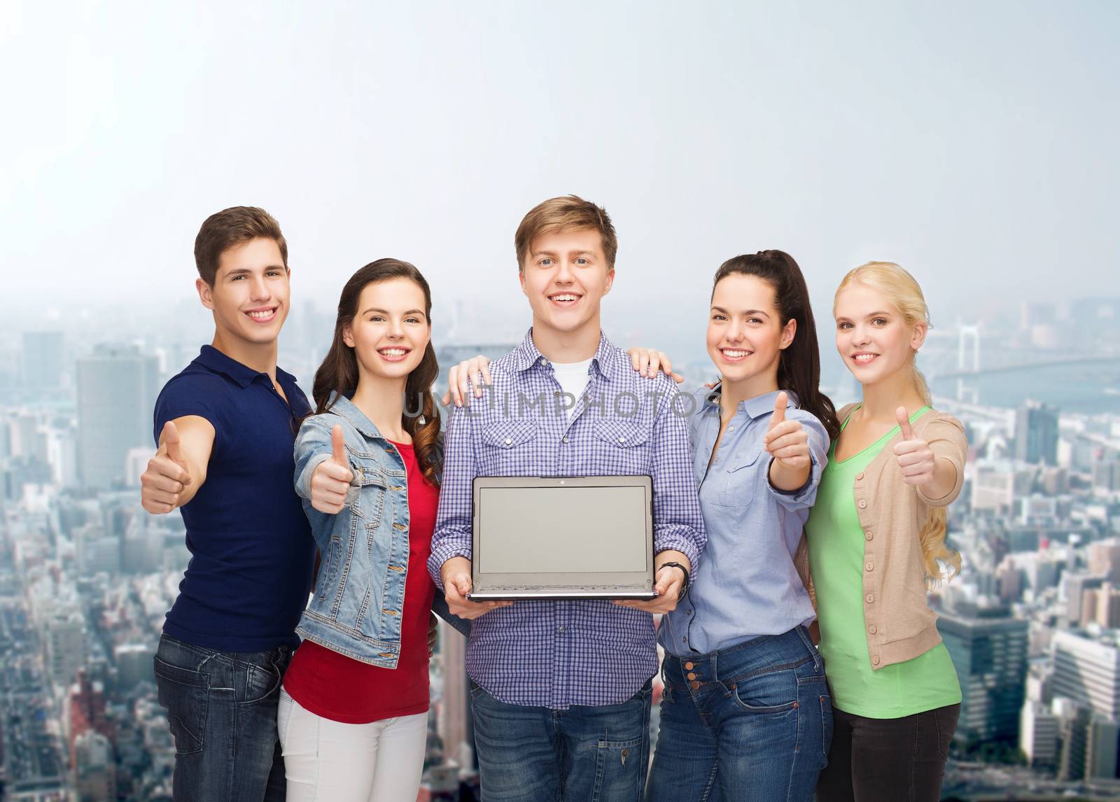 smiling students with laptop computer by dolgachov