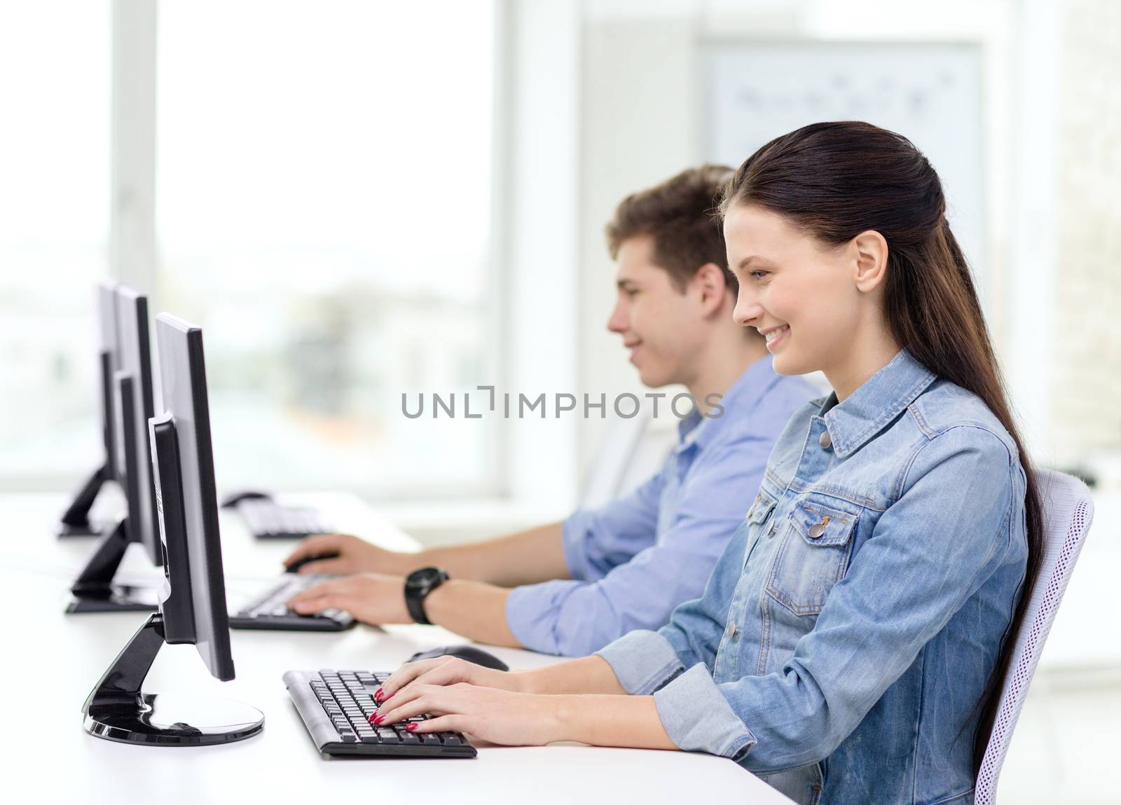 two smiling students in computer class by dolgachov