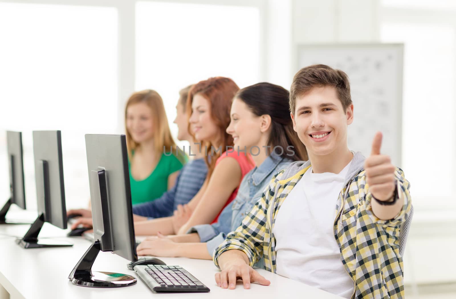 male student with classmates in computer class by dolgachov