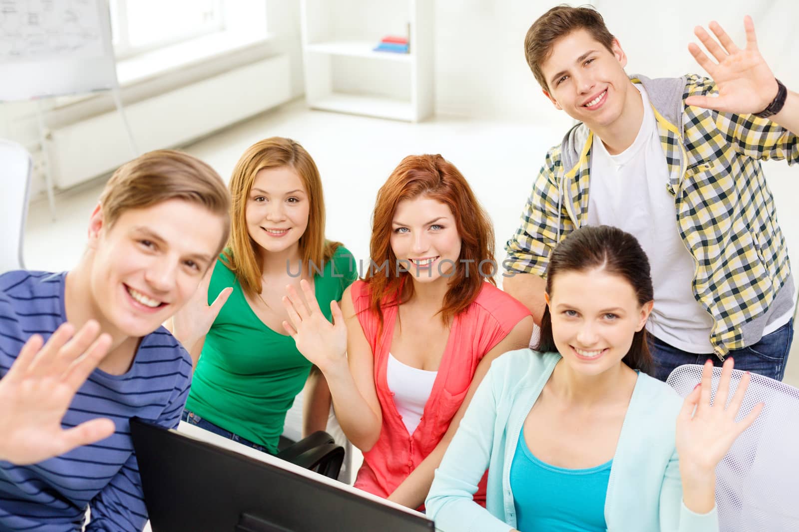 group of smiling students waving hands at school by dolgachov