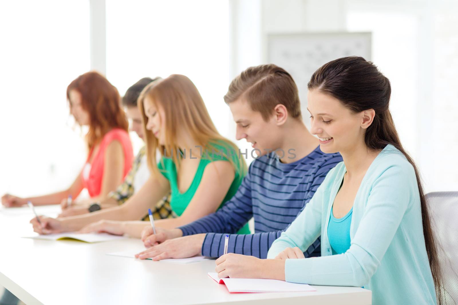 education and school concept - five smiling students with textbooks at school