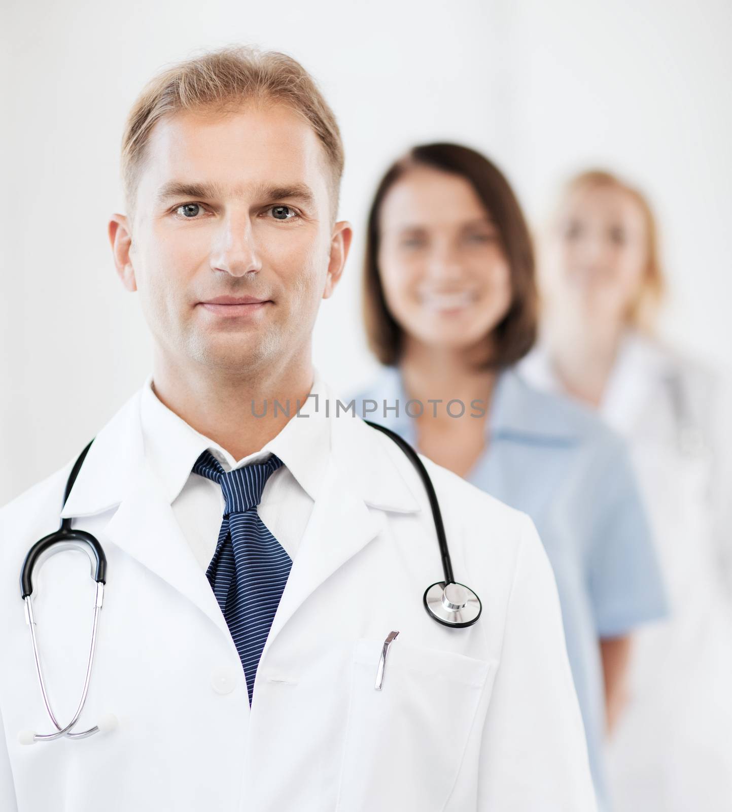 healthcare and medical concept - male doctor with stethoscope and colleagues