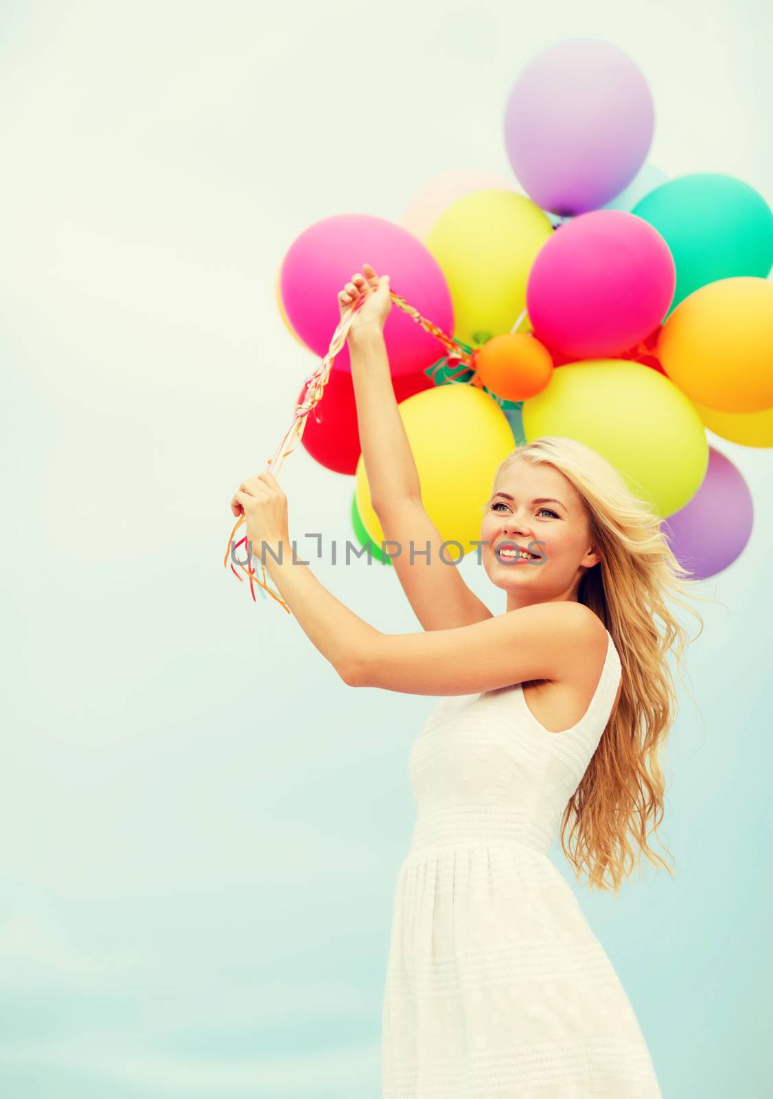 smiling woman with colorful balloons outside by dolgachov