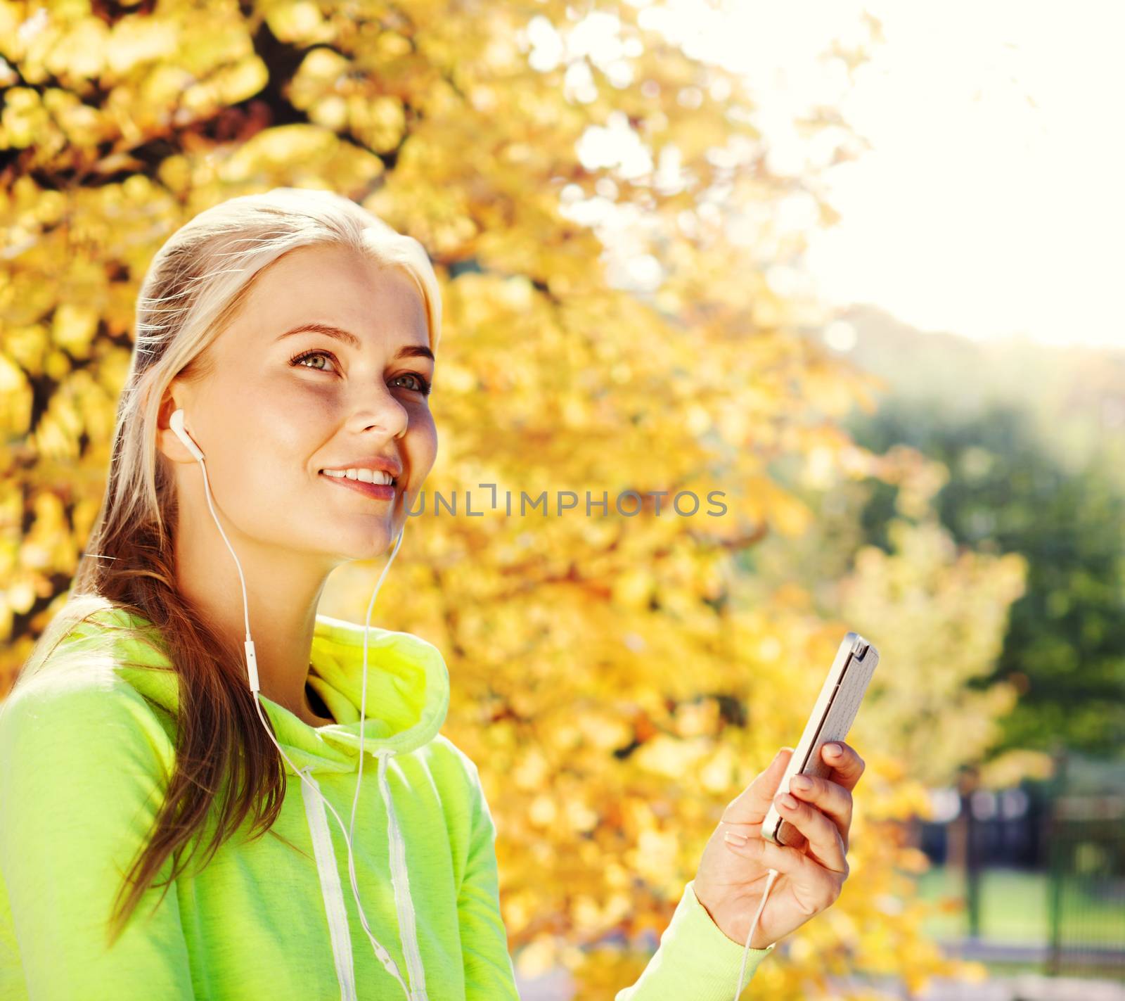 sport and lifestyle concept - woman doing sports and listening to music outdoors