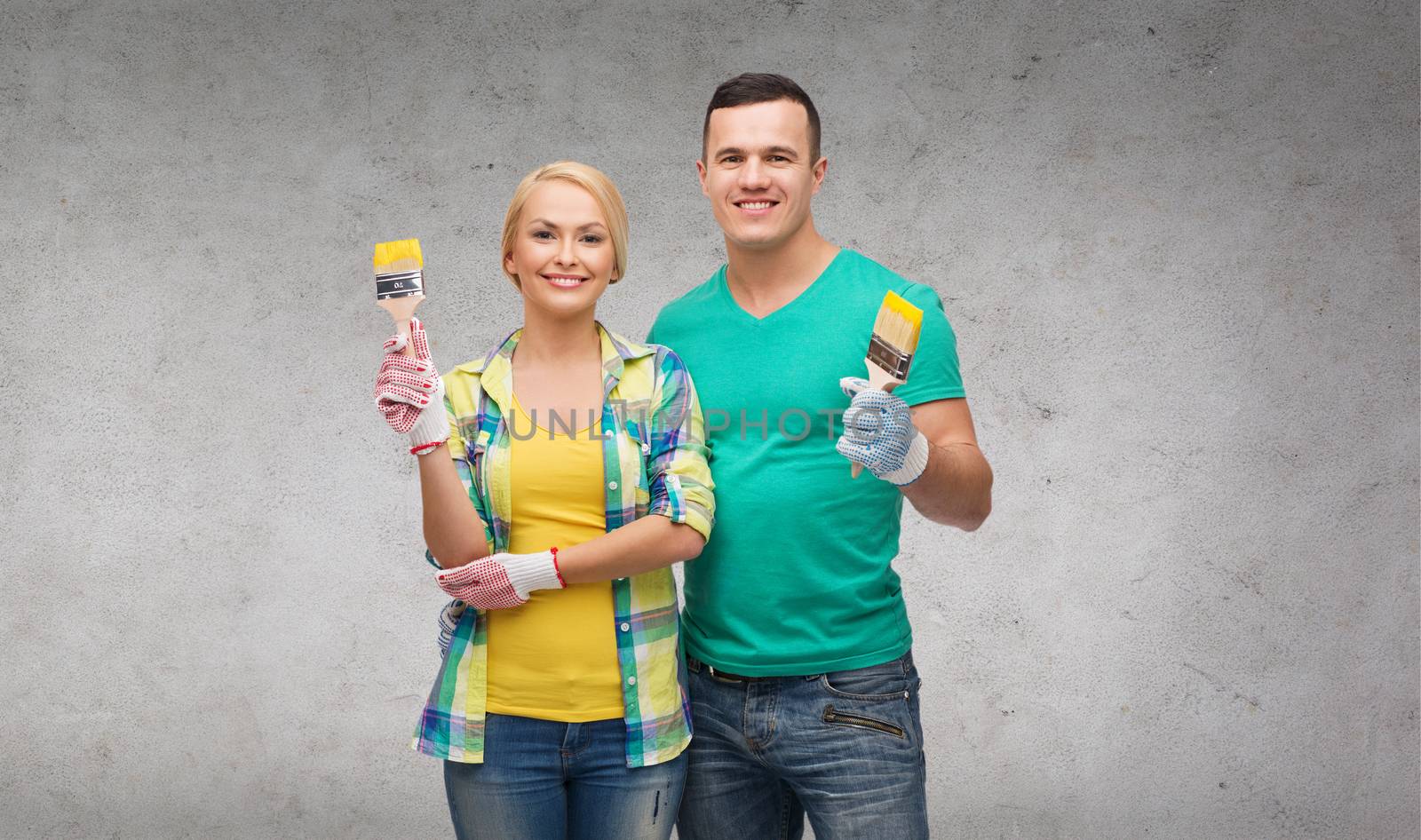 repair, construction and maintenance concept - smiling couple with paintbrush