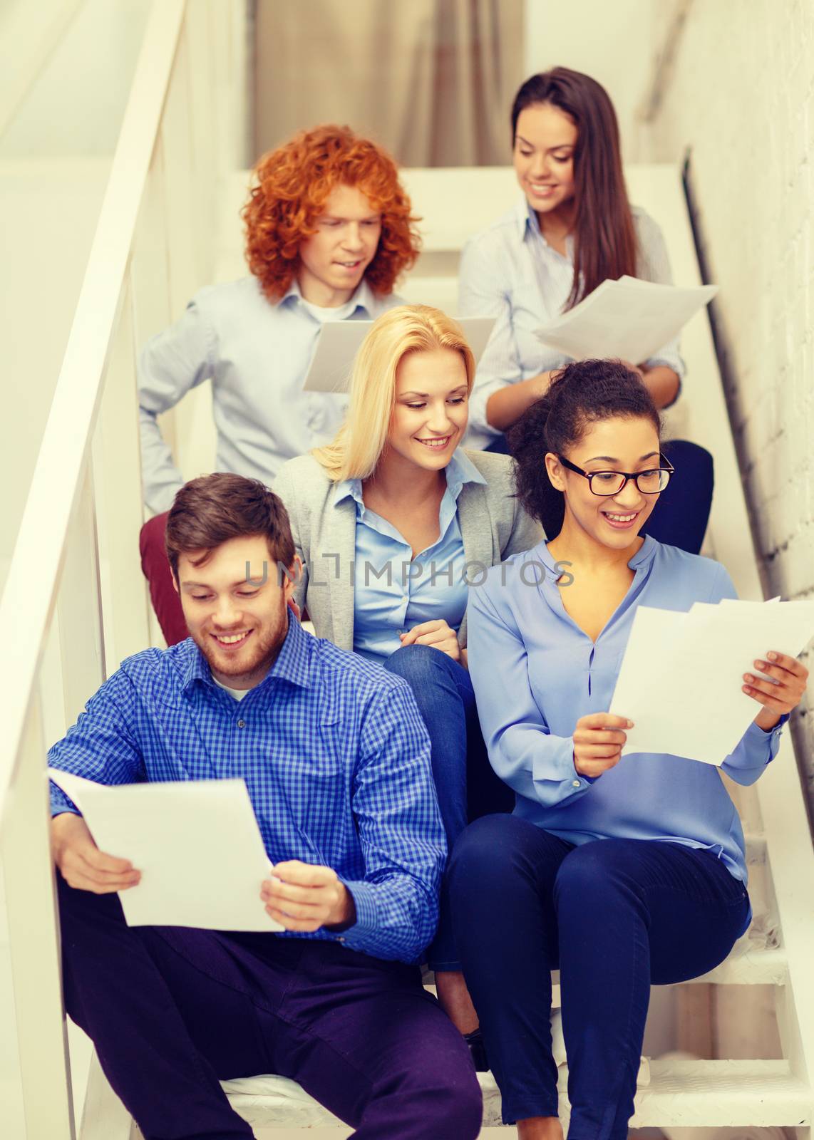 team with papers and take away coffee on staircase by dolgachov