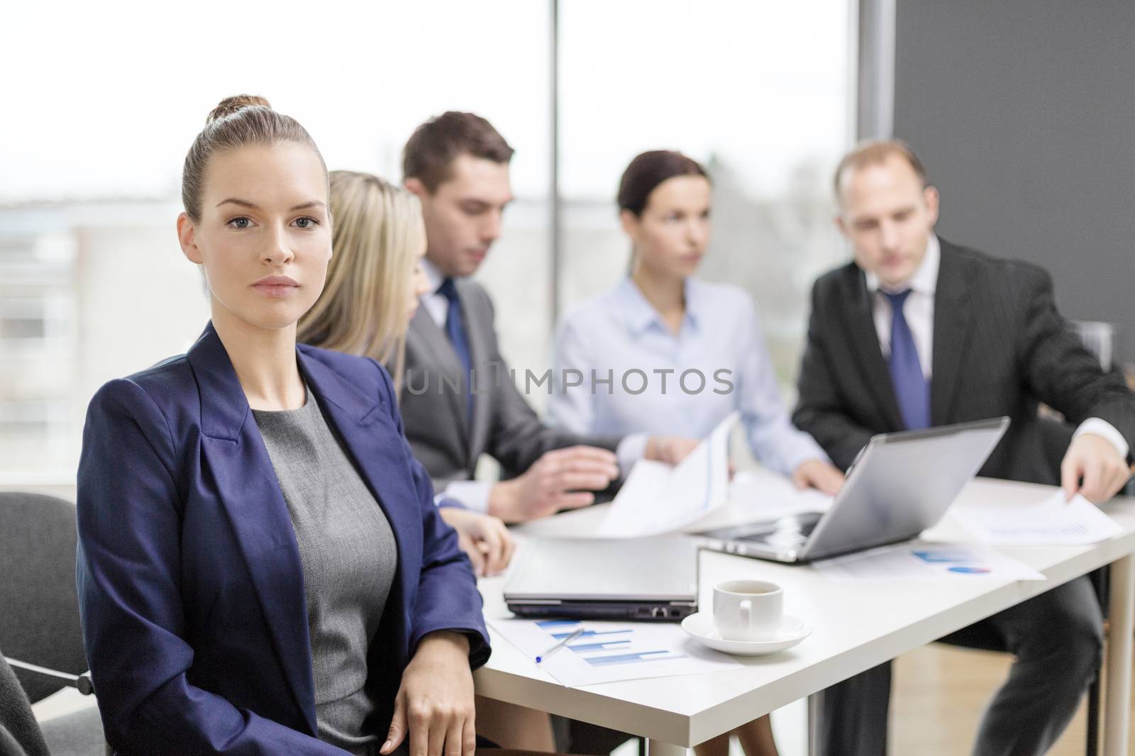 businesswoman in office with team on the back by dolgachov