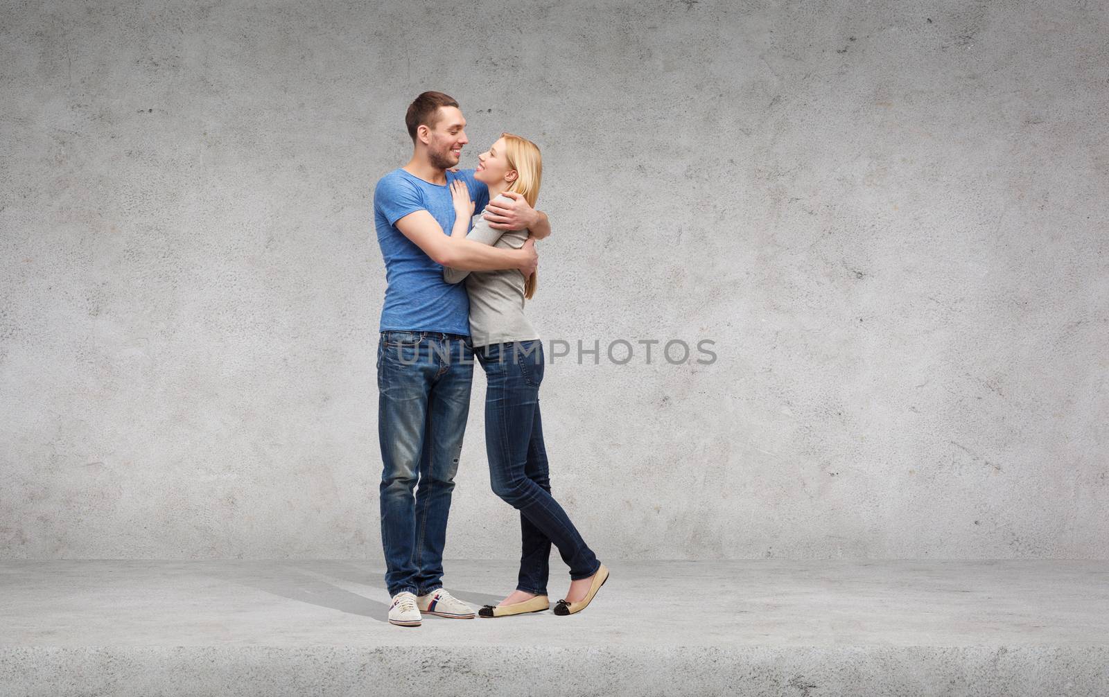 smiling couple hugging and looking at each other by dolgachov