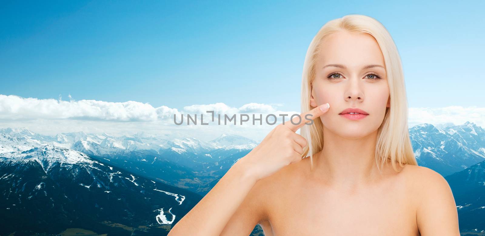calm young woman pointing at her cheek by dolgachov