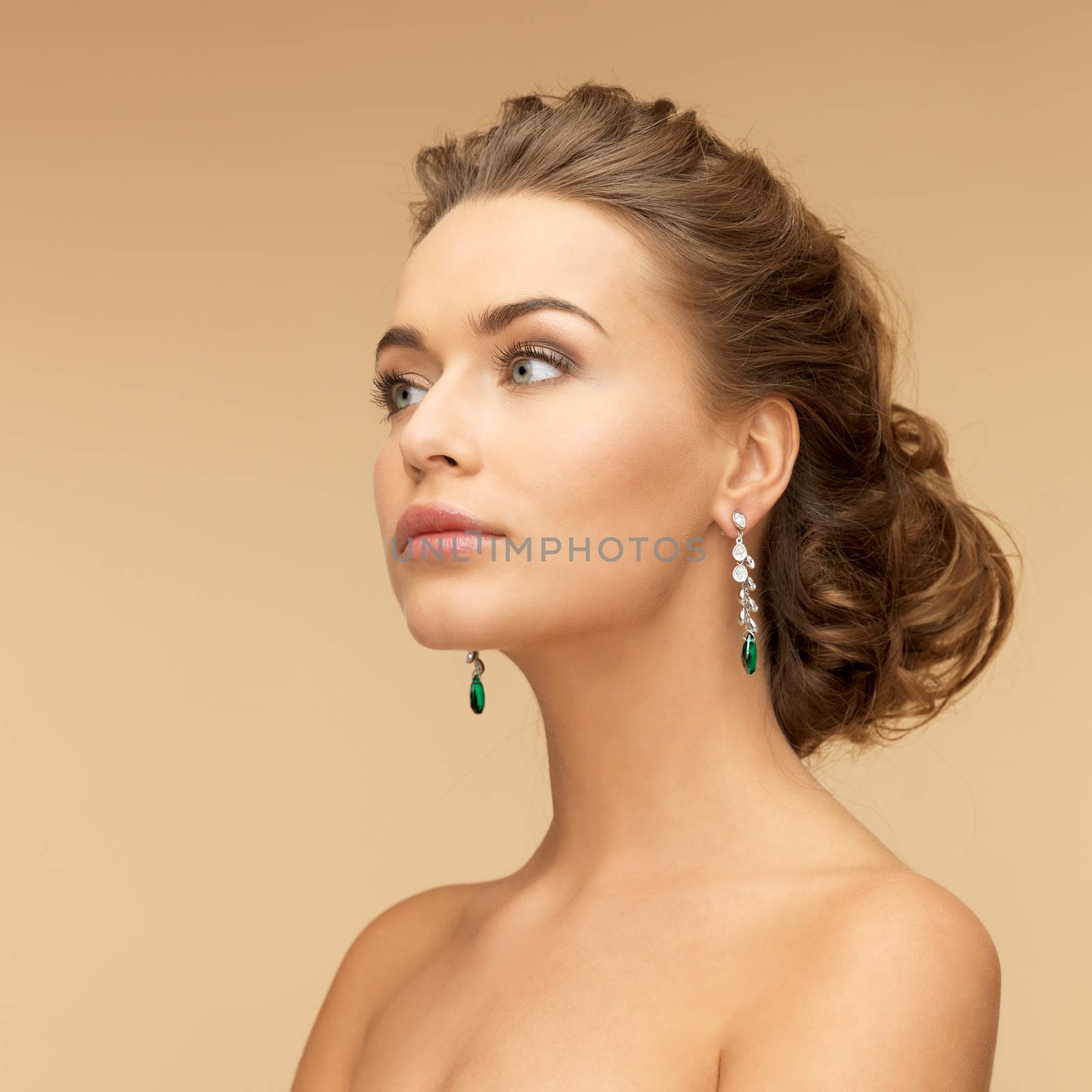 beauty and jewelry concept - beautiful woman in diamond and emerald earrings