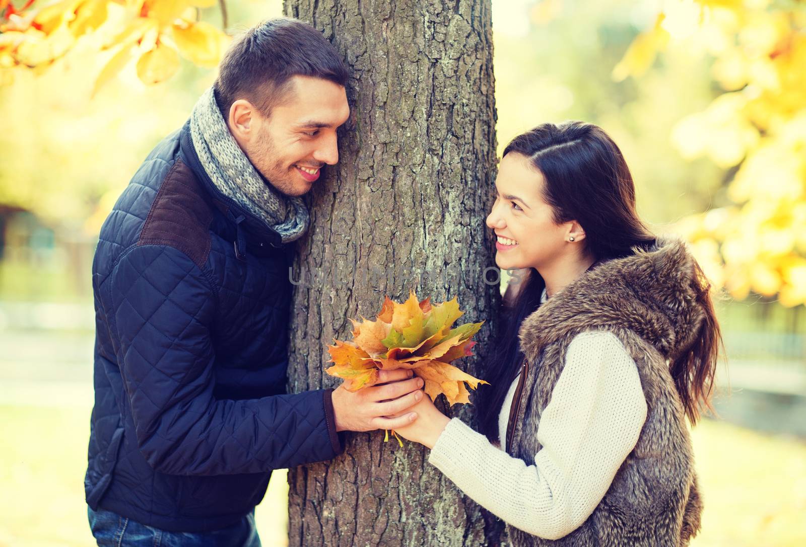 holidays, love, travel, relationship and dating concept - romantic couple playing in the autumn park