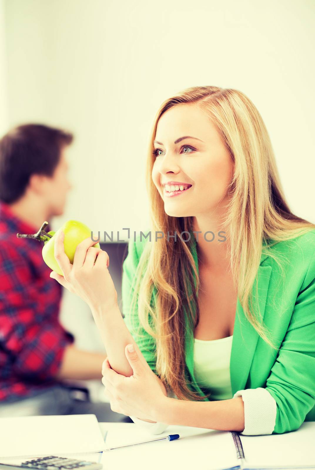 student girl with green apple in college by dolgachov