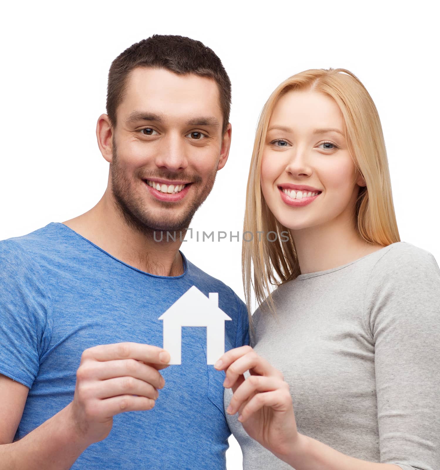 smiling couple holding white paper house by dolgachov