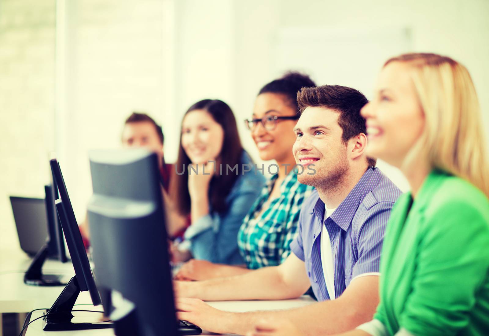 students with computers studying at school by dolgachov