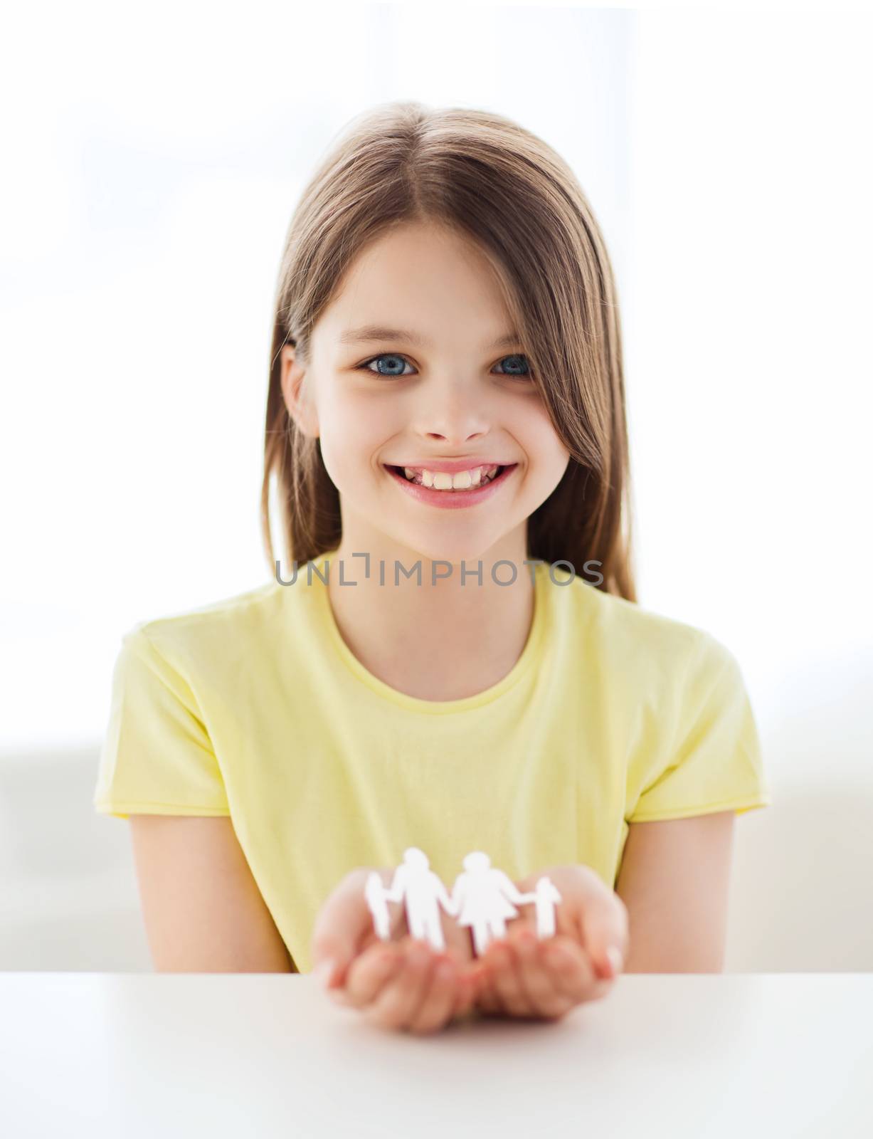 family, childhood, home and happiness concept - smiling little girl showing paper man family