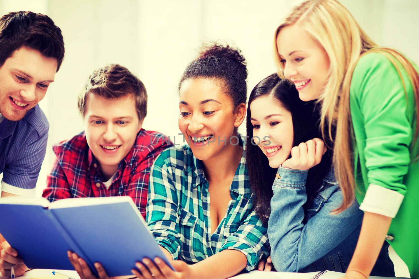 education concept - group of students reading book at school