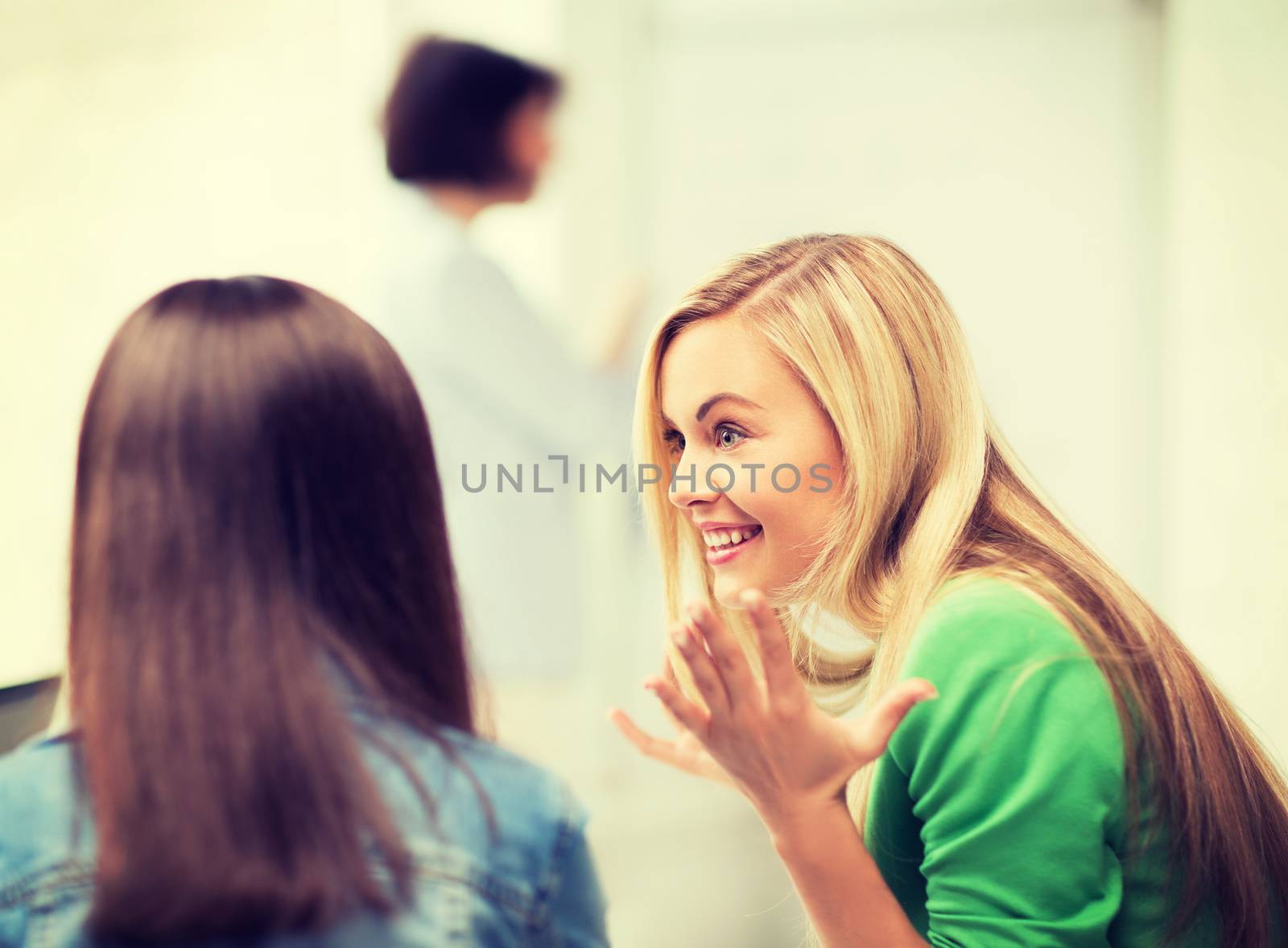 education concept - attractive student girl gossiping in lecture at school