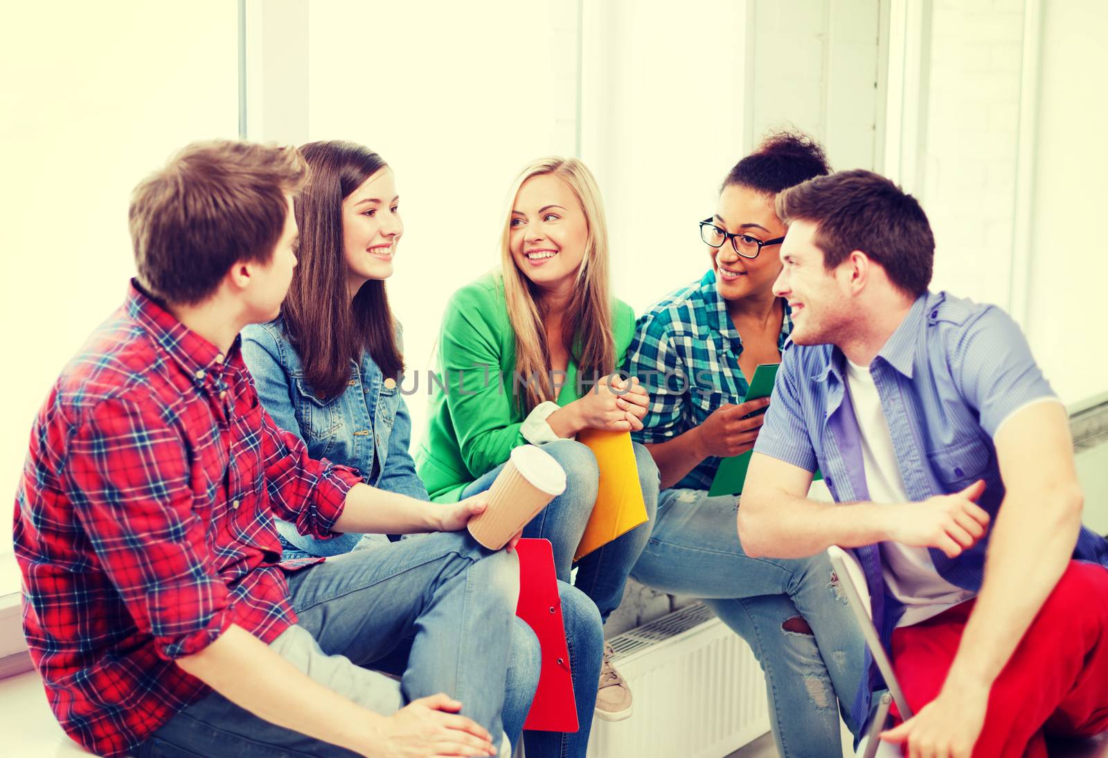 students communicating and laughing at school by dolgachov