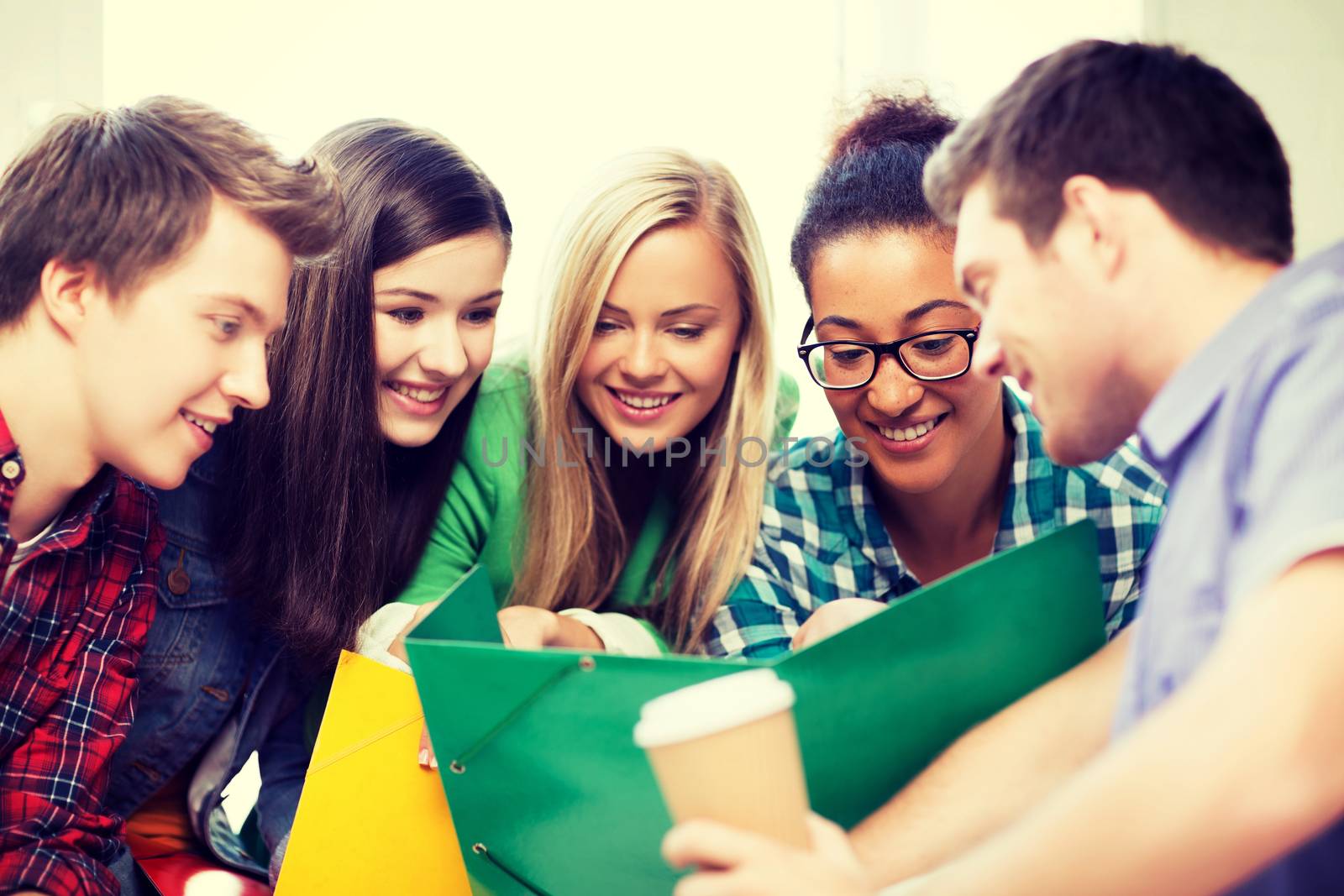 education concept - students looking at notebook at school