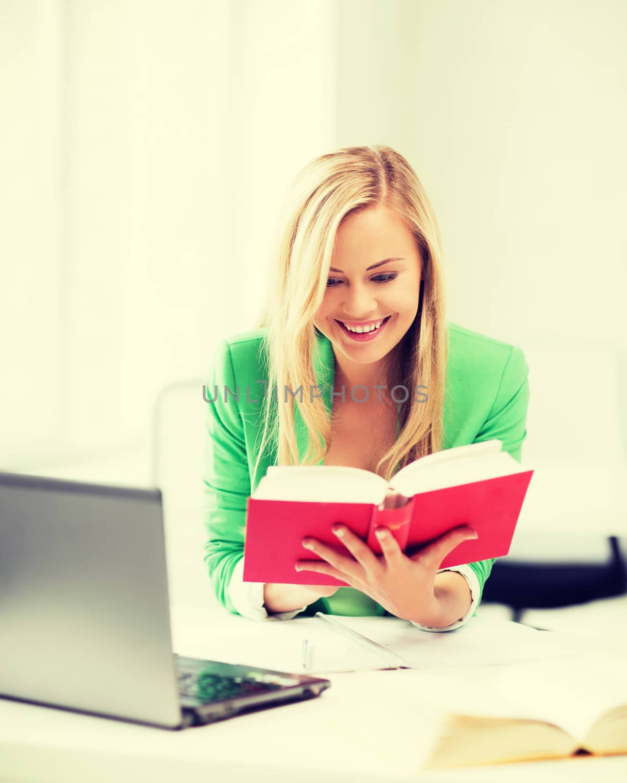 education concept - smiling student girl reading book in college