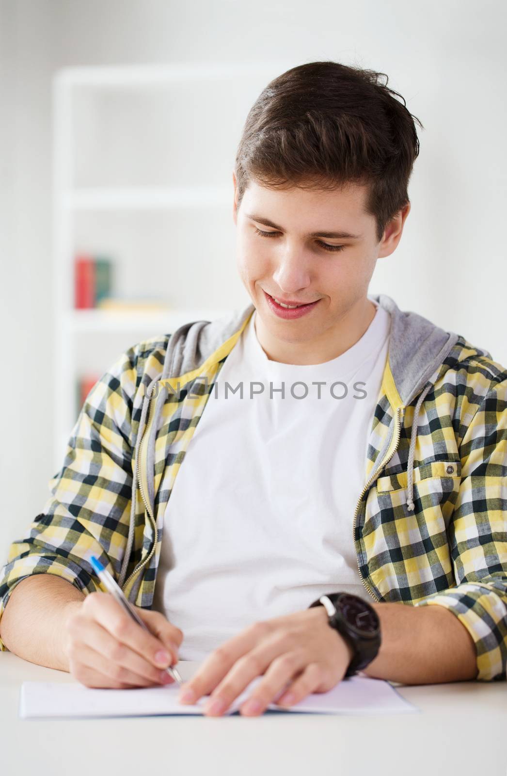 education and school concept - smiling student with textbook at school