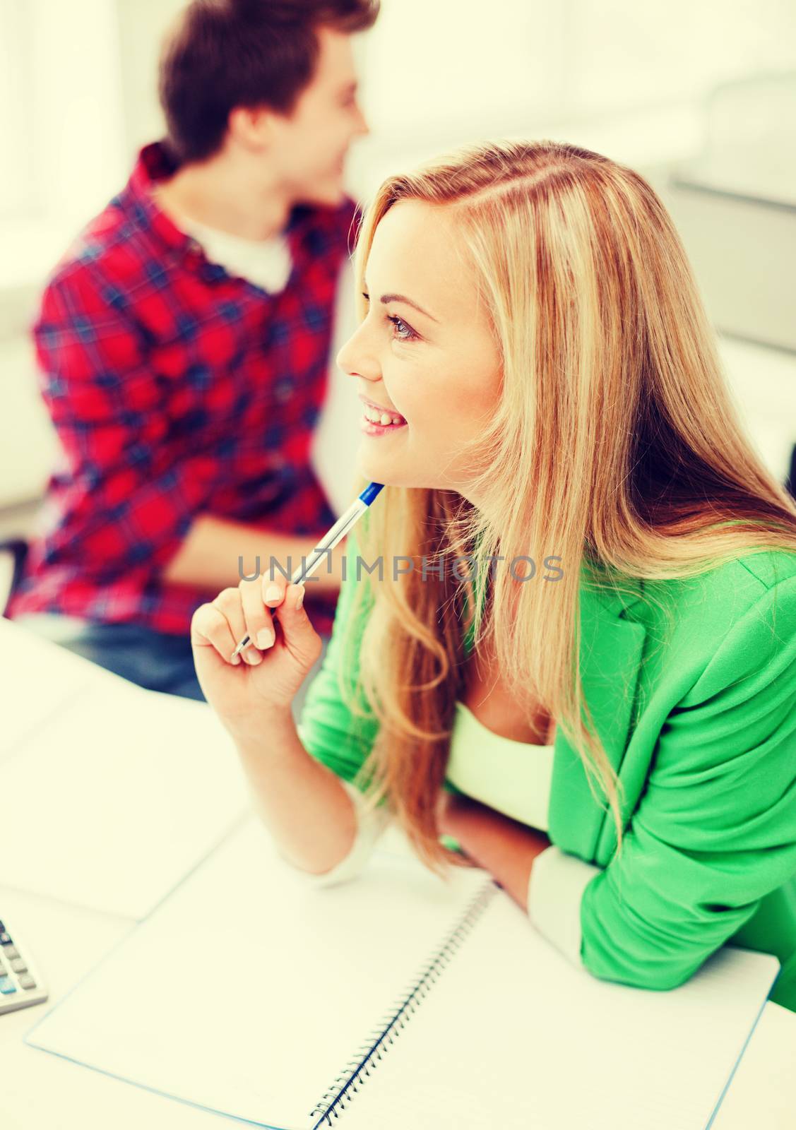 education concept - smiling student girl studying in college