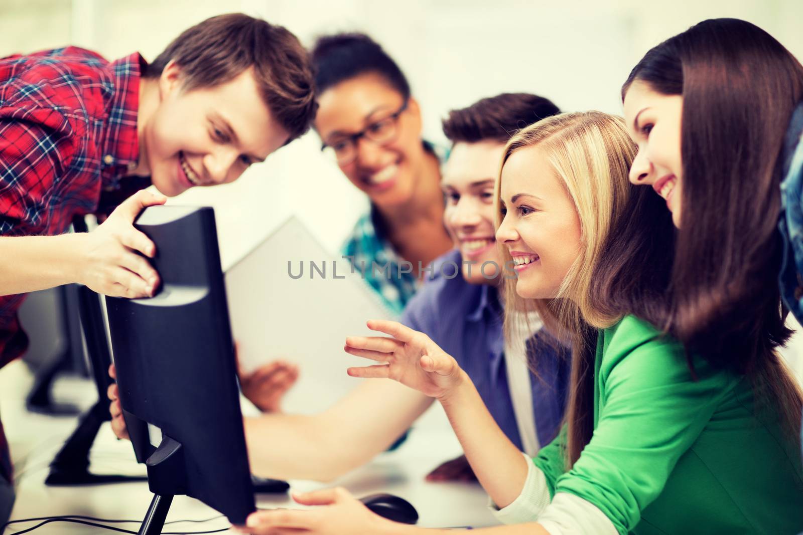 education concept - students looking at computer monitor at school