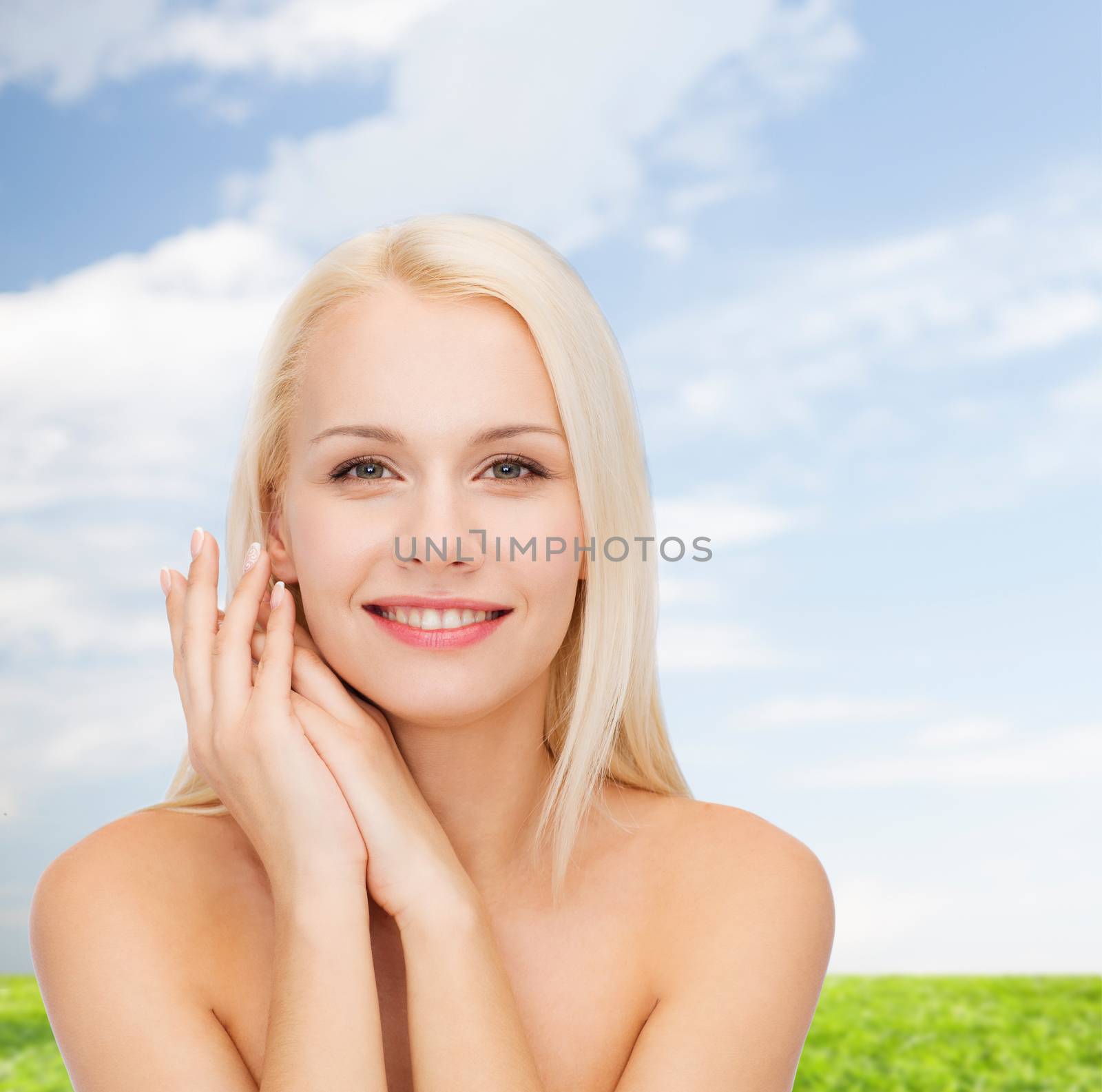 health and beauty concept - face and hands of happy woman