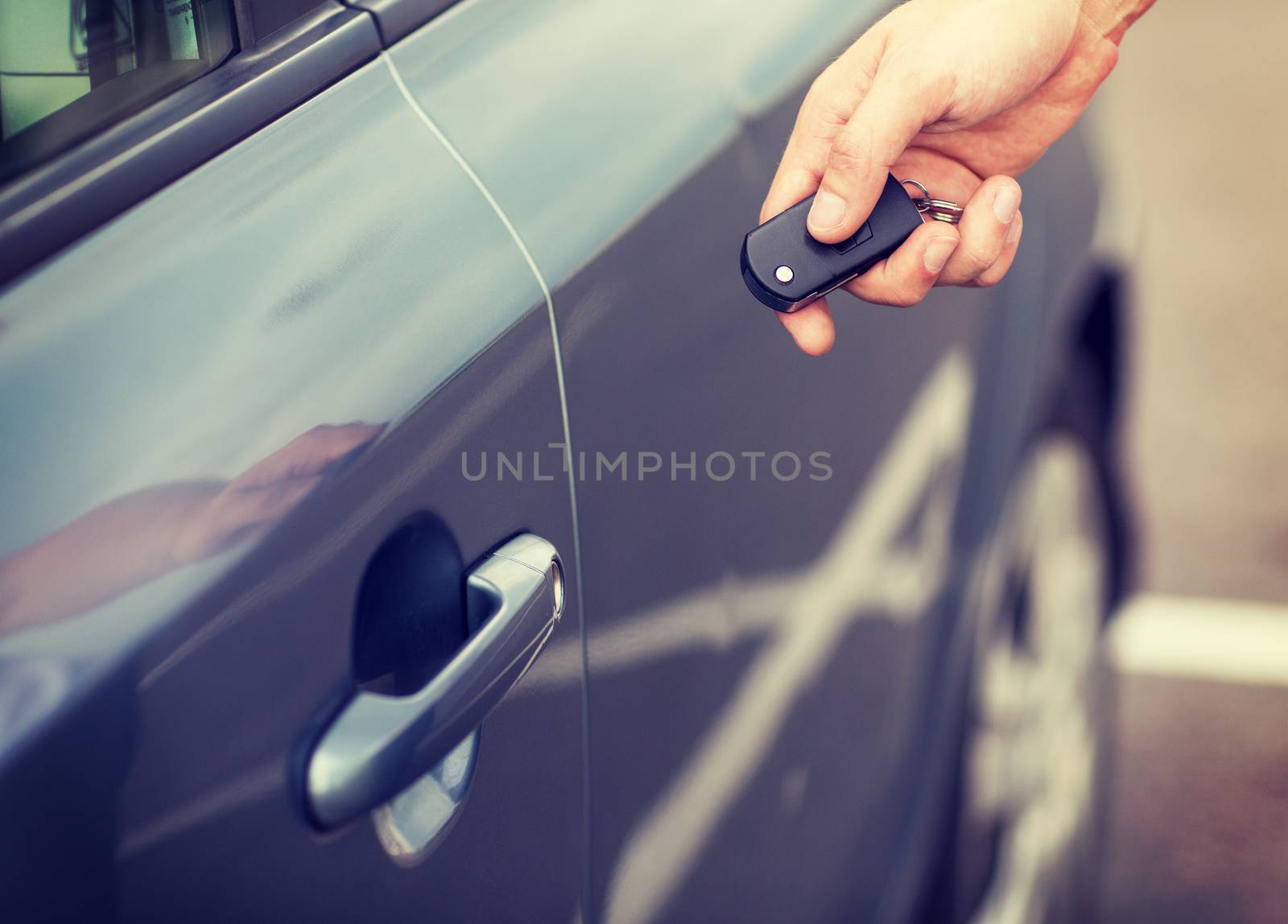 transportation and ownership concept - man with car key outside