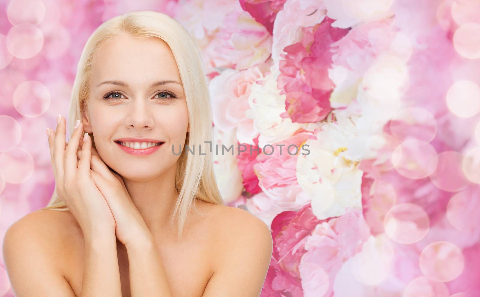 health and beauty concept - face and hands of happy woman