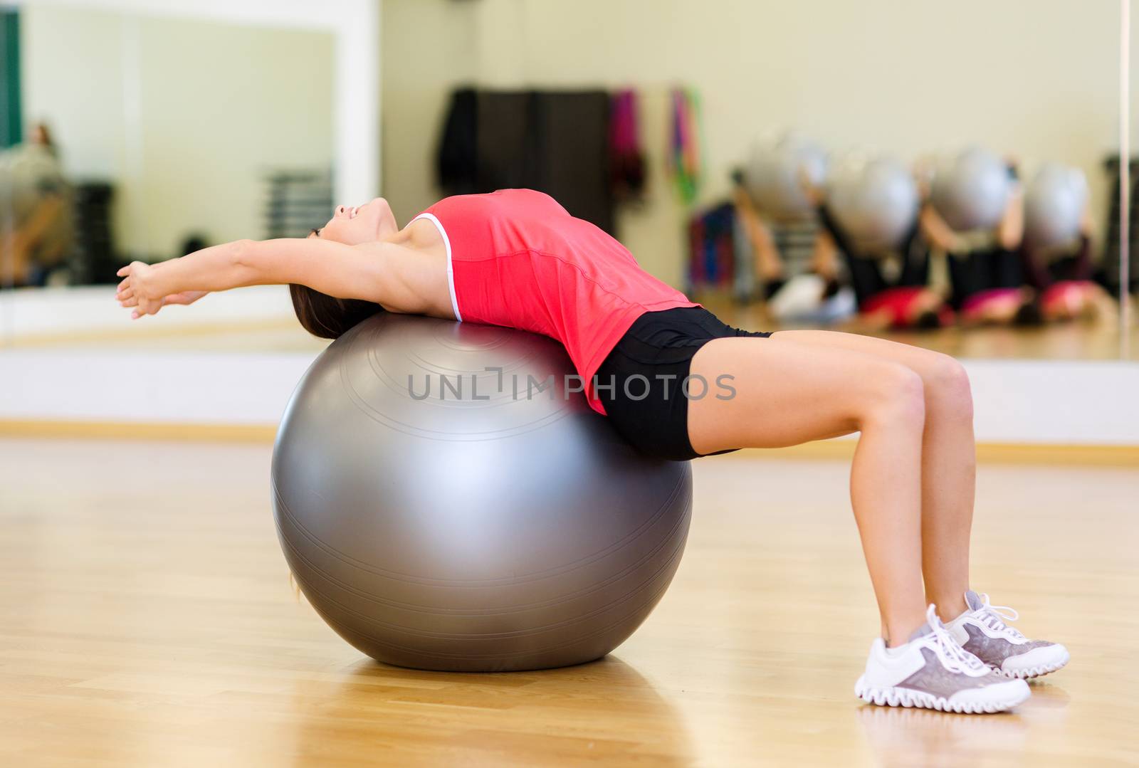 young woman doing exercise on fitness ball by dolgachov